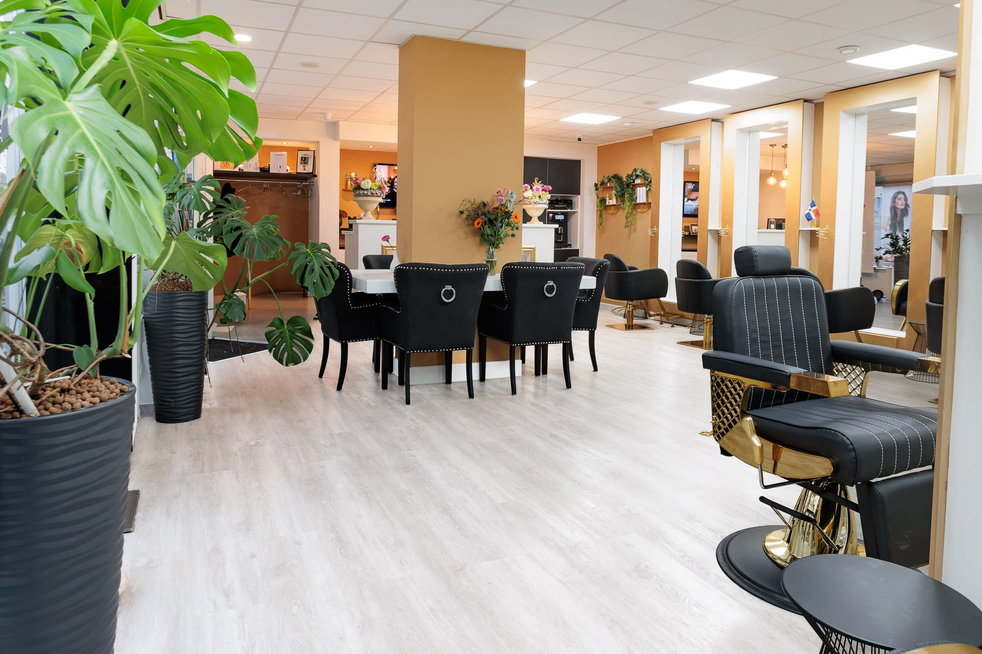 Warme salonruimte met planten, zitgedeelte en luxe stylingstoelen bij Yensi Style